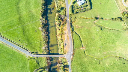 Aerial view on a farmland with bridge crossing small river. Coromandel, New Zealand