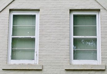 Fototapeta na wymiar Gray brick wall with two white windows