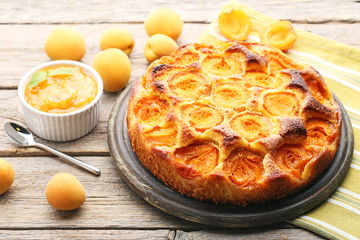 Apricot pie with fruits on grey wooden table
