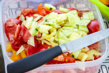 Tomato and Cucumber salad. Vegetarian Diet. On top of the salad lies a knife
