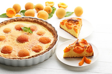 Slices of apricot pie on white wooden table