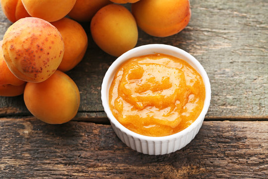 Apricot jam in bowl on grey wooden table