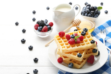 Sweet waffle with berries, milk and honey on white wooden table - obrazy, fototapety, plakaty