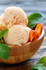 Homemade peach ice cream in a wooden bowl.