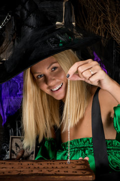 happy witch blonde with a Ouija board and crystal guessing