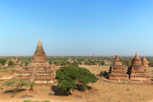 Many old pagodas and other buildings at the ancient plain of Bagan in Myanmar (Burma), viewed from the Bulethi (Buledi) Temple on a sunny day.