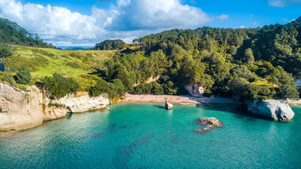 Fototapeta premium Aerial view on a remote ocean coast with small coves and mountains on the background. Coromandel, New Zealand.