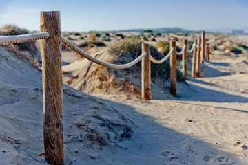 Rope fence on the sandy beach of La Mata. Sunset on the beach. Blurred unfocused background 02