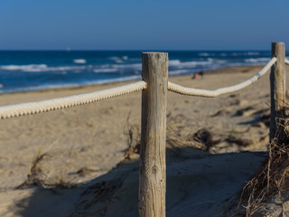 Rope fence on the sandy beach of La Mata. Sunset on the beach. Blurred unfocused background 01