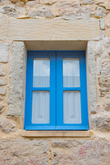 Blue wooden window in a stone house