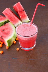 Watermelon cocktail and slices of watermelon on an old rusty background
