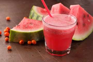 Watermelon cocktail and slices of watermelon on an old rusty background