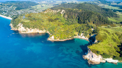 Aerial view on a remote ocean coast with small coves and mountains on the background. Coromandel, New Zealand.