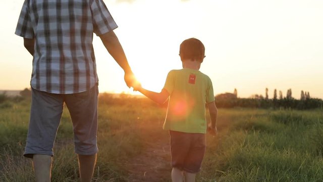 Father and son playing  at the sunset time. People having fun outdoors. Concept of friendly family.