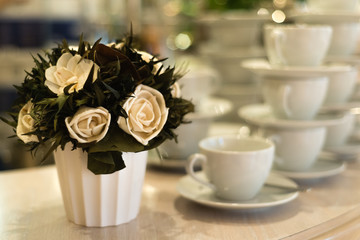 Many rows of pure white coffee cups on white table