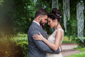Bride and groom in a park kissing.couple newlyweds bride and groom at a wedding in nature green forest are kissing photo portrait.Wedding Couple