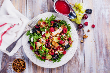 Delicious summer salad with mix of berries, nuts, feta cheese and bacon. Space for text. Top view