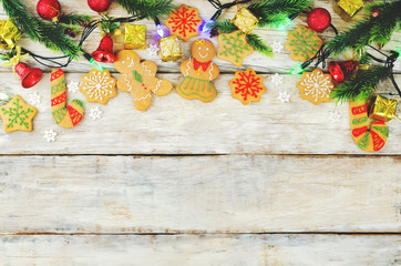 Wood background with gingerbread cookies, Christmas tree and Christmas light