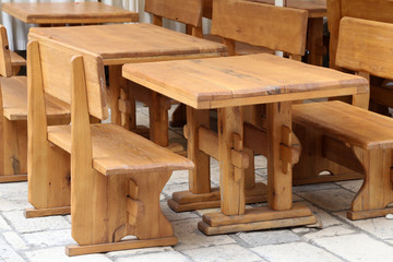 Fototapeta na wymiar Wooden tables and benches in a street cafe