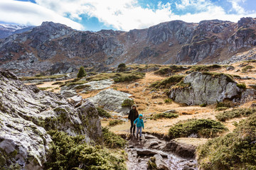 Fototapeta premium Woman with son hiking the mountains having a good time