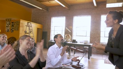 Businesswoman leads a presentation at motivational event with clapping