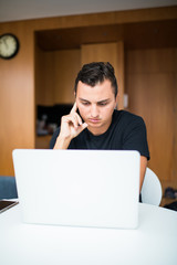 Man sitting at desk working from home on laptop in the morning