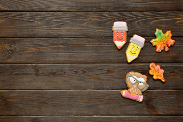 Back to school concept background with colored pencils, red appple and gingerbread on wooden table