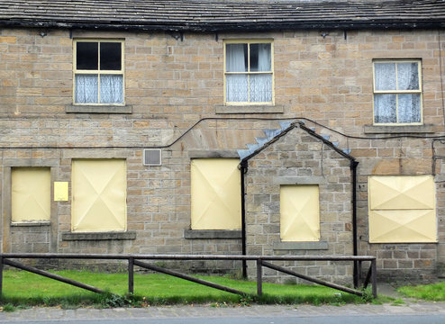 derelict abandoned terraced housing in england with boarded up windows
