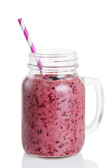 Smoothies of blueberry, banana and orange in a glass jar isolated on white background