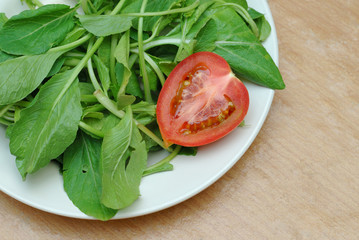 tomato slice and green lettuce on plate