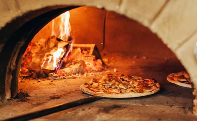 Tuinposter Italiaanse pizza wordt gekookt in een houtgestookte oven. © andrew_shots