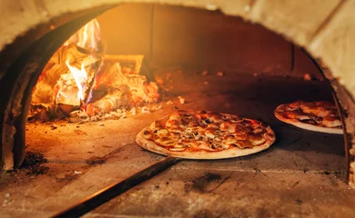 Zelfklevend Fotobehang Italiaanse pizza wordt gekookt in een houtgestookte oven. © andrew_shots