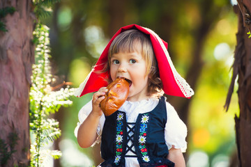 Little Red Riding Hood bites a patty in the forest.