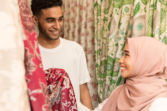 Young muslim couple smiling in fabric store