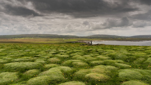 Grüne Wellen und grauer Himmel in Irland
