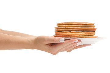 Female hand holding pancakes on a plate