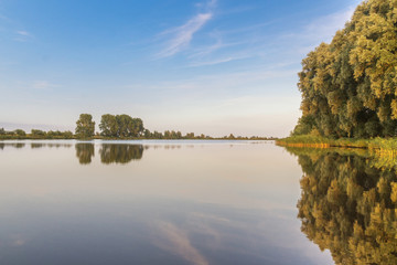 Fluss im Sonnenlicht mit Schilf am Ufer