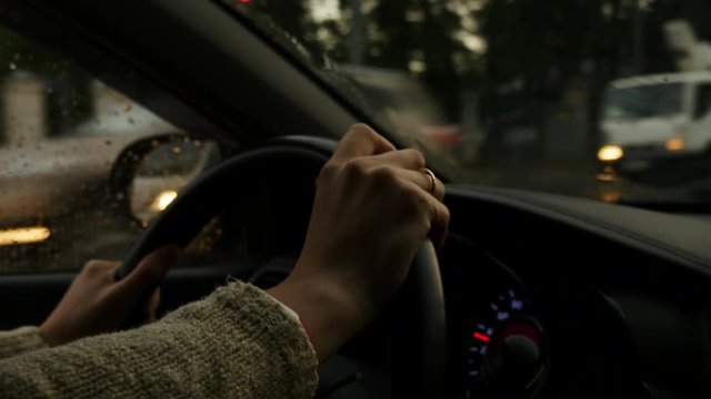 Woman Hands On Steering Wheel Of A Car In Rainy Weather