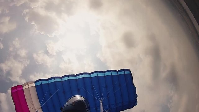 Skydiver in helmet flying on parachute in sky. Height. Extreme sport. Speed. Adrenaline.