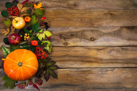 Thanksgiving decor with leaves and squash on wooden table