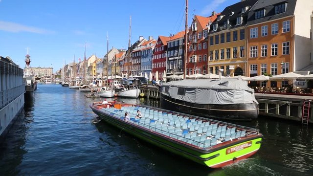 COPENHAGEN, DENMARK - JULY 25: Nyhavn district is one of the most famous landmark in Copenhagen. eople enjoy sunny weather in open cafees in Copenhagen on July 25, 2014