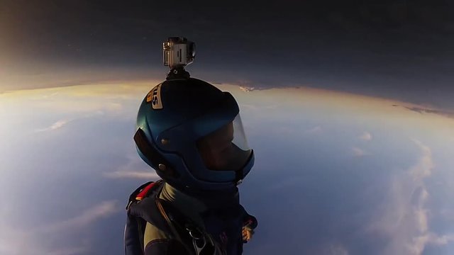 Professional skydivers in uniform free falling in sky. Open parachute. Sunset. Adrenaline.
