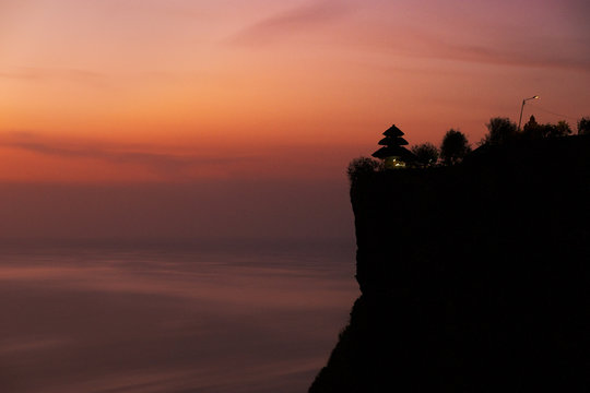 Alone temple on a strong cliff in a beautiful twilight at Uluwatu, Bali, Indonesia - Powered by Adobe