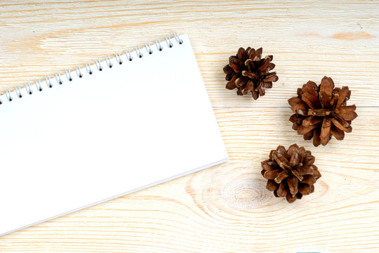 notepad with pine cones on white wooden planks, autumn card template