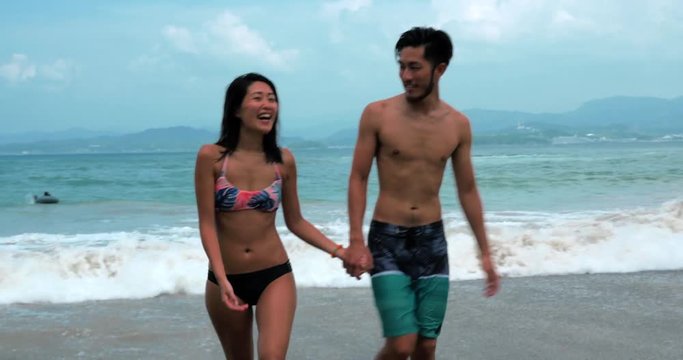 Beautiful couple walking onto the beach after a swim.