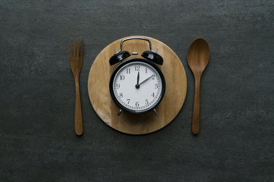 Food clock at lunch time. Healthy food concept on wooden table