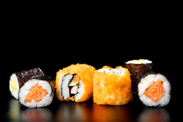 Sushi rolls on black background, Japanese food.