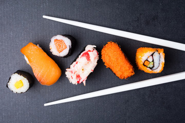 Top view of Sushi set and chopsticks on black background, Japanese food.