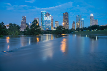 Reflection of Downtown Houston skyscrapers on a pond of overflow water from Bayou River to Eleanor Park after Harvey tropical storm. Heavy rain of hurricane Harvey caused many flooded areas in Houston