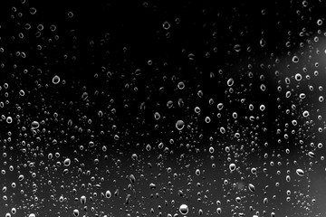 Fototapeta na wymiar Raindrops on black glass